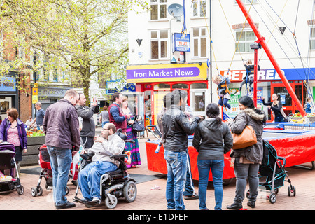 Eltern fotografieren, lachen, plaudern, während ihre Kinder spielen auf Bungee-Schaukel im Zentrum der Stadt Newcastle unter Lyme, Stockfoto