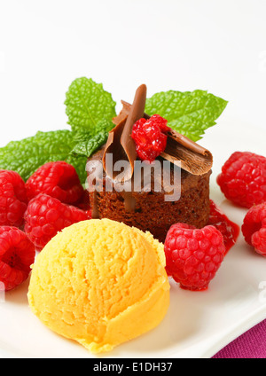 Mini-Schokoladen-Kuchen mit frischen Himbeeren und Kugel Eis serviert Stockfoto