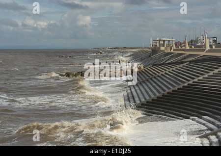 Blauer Himmel graue Wolken sehen, Blick nach Norden zu Rossall, Flut Meereswellen schlagen Schritte Cleveleys Promenade, Fylde Küste, UK Stockfoto