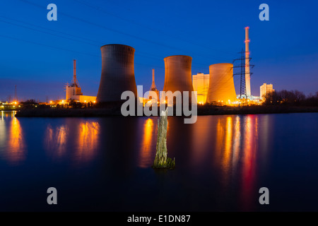 Ein Kohlekraftwerk in Flusslandschaft mit toten Bäumen in der Nacht Stockfoto