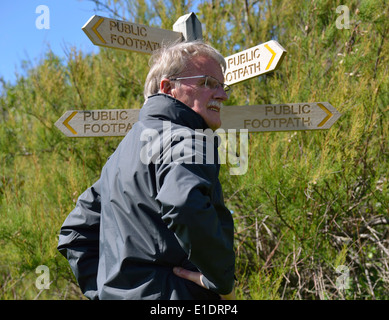 Mann, der eine Auswahl an Richtung stand neben einem öffentlichen Wanderweg-Zeichen am Snow Hill, West Wittering, West Sussex, UK Stockfoto