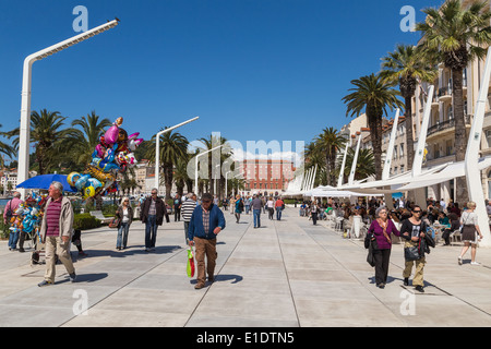 Lokalen Bevölkerung und Touristen zu Fuß entlang der Riva in split Kroatien. Cafés und Restaurants säumen die Seite. Ballons schweben im wind Stockfoto