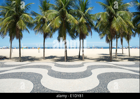 Kultige geschwungene Bürgersteig Fliesenmuster mit Palmen am Copacabana Strand Rio de Janeiro Brasilien Stockfoto