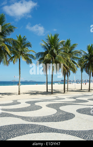 Kultige Bürgersteig Fliesenmuster mit Palmen am Copacabana Strand Rio de Janeiro Brasilien Stockfoto