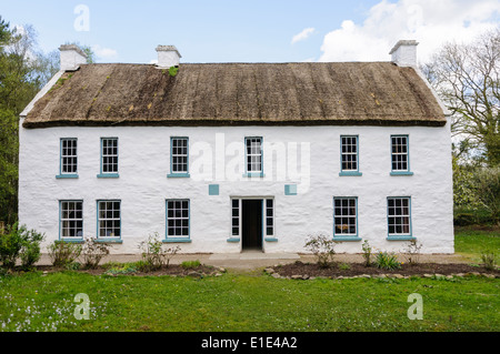 Ein sehr großes irischen Bauernhaus mit weiß getünchten Wänden und einem Strohdach in Ulster American Folk Park, Nordirland Stockfoto