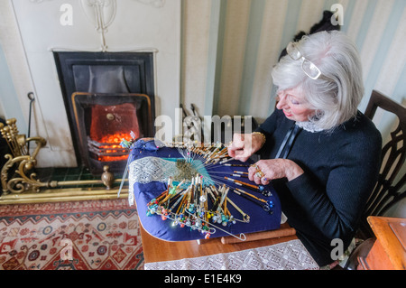 Eine Frau basteln komplizierte Spitze mit alten altmodischen Spulen in ihr Haus. Stockfoto