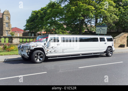 Eine weiße Hummer Stretchlimousine mit roten Bändern Hochzeit Dekoration Stockfoto