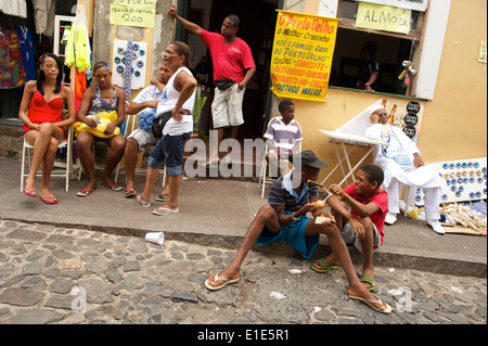 SALVADOR, Brasilien - 27. Februar 2014: Junge Brasilianer knüpfen auf die Straße mit Kopfsteinpflaster von Pelhourinho vor Karneval. Stockfoto