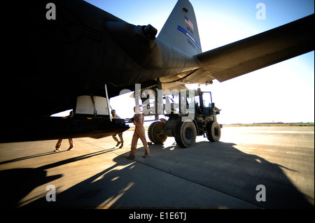 U.S. Air Force Tech Sgts. Owen Duke Jr. und Adam Nixon laden humanitäre Güter in eine C - 130H Hercules-Flugzeuge bei Bagra Stockfoto