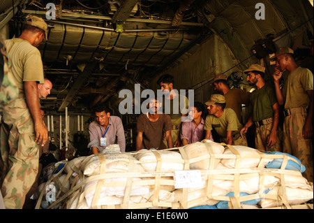 Pakistanische Soldaten und US-Flieger aus der 746th Expeditionary Airlift Squadron entladen Fracht aus einer c-130 Hercules-Flugzeuge in Stockfoto