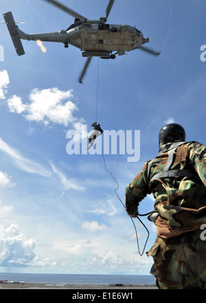 US Navy Diver 2. Klasse Brody Dorton, Explosive Ordnance Mobile Abfallbehälter 5 zugewiesen Abseilung von einem HH - 60H Sea Hawk Stockfoto