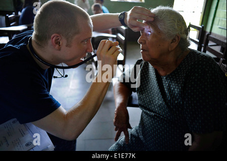 U.S. Navy Lt. Daniel Bowers, links, eingeschifft auf amphibischer Angriff Schiff USS Iwo Jima (LHD-7), untersucht einen Patienten während Stockfoto