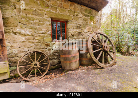 Fässer und Wagenräder außerhalb eine alte irische Farm cottage Stockfoto