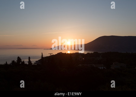 Dorf Fiskardo, Kefalonia. Malerischen Sonnenaufgang über der Ionischen Insel Ithaka mit Fiskardo im Vordergrund. Stockfoto