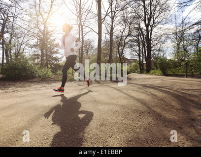 Gesunde junge Frau im Park Joggen. Fitness weibliches Modell in Wald laufen. Kaukasische Fitness-Modell Bewegung in der Natur. Stockfoto
