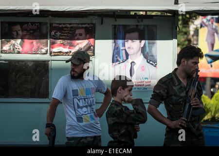 (140602)--Damaskus, 2. Juni 2014 (Xinhua)--syrische Armee Soldaten Wache vor dem Plakat des Präsidentschaftskandidaten Baschar al-Assad an einem Kontrollpunkt in Damaskus, die Hauptstadt Syriens, am 1. Juni 2014, vor den Präsidentschaftswahlen am 3. Juni. (Xinhua/Pan Chaoyue) Stockfoto