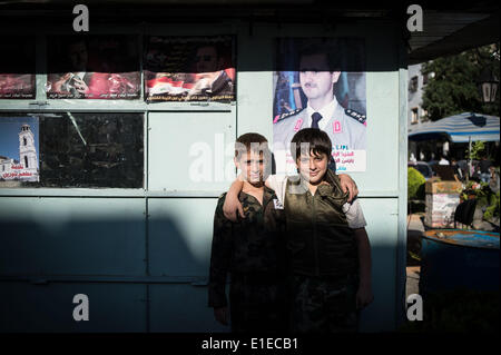 (140602)--Damaskus, 2. Juni 2014 (Xinhua)--syrischen Jungs posieren vor dem Plakat des Präsidentschaftskandidaten Baschar al-Assad in Damaskus, die Hauptstadt Syriens, am 1. Juni 2014, vor den Präsidentschaftswahlen am 3. Juni. (Xinhua/Pan Chaoyue) Stockfoto