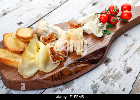 Käse auf Brett mit Cherry-Tomaten, getrocknete Feigen und Scheiben Brot Stockfoto