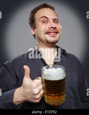 Zufrieden Mann mit Bier auf einem dunklen Hintergrund. Studio-Fotografie. Stockfoto