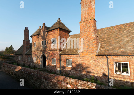 Am Abend Sonnenlicht auf der Vorderseite der Ziegel von der Trinity Hospital Armenhäuser in Castle Rising, Norfolk. Stockfoto