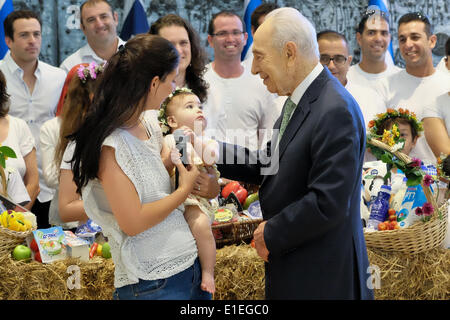 Jerusalem, Israel. 2. Juni 2014. Israels Präsident SHIMON PERES wird ein neugeborenes Kind in die Gewohnheit des Kibbuz präsentiert. Der Präsident fand ein Bikkurim Festival für den Feiertag von Shavuot, feiert die Übergabe der Tora am Berg Sinai. Auch bezeichnet als das Erntedankfest in antike jüdische Bauern ihre ersten Früchte der Saison auf dem Tempel in Jerusalem als Opfergaben gebracht. Bildnachweis: Nir Alon/Alamy Live-Nachrichten Stockfoto