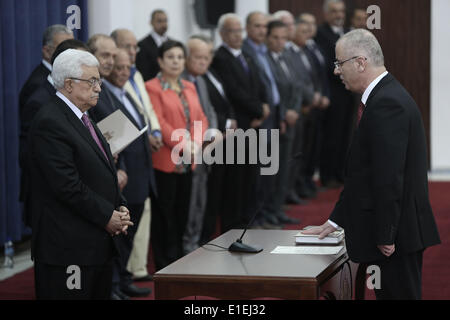 (140602)--RAMALLAH, 2. Juni 2014 (Xinhua) - Palestinian Prime minister Rami Al-Hamdallah (R) nimmt Amtseid vor Präsident Mahmoud Abbas (L-vorne) während der Vereidigung für die neue Regierung der Einheit in der West bank Stadt Ramallah auf 2. Juni 2014. Palästinenserpräsident Mahmoud Abbas hat am Montag angekündigt, zum Jahresende eine sieben Jahre währende politische Spaltung zwischen seiner Fatah-Partei und der islamischen Hamas-Bewegung. (Xinhua/Fadi Aruri) (Zjy) Stockfoto