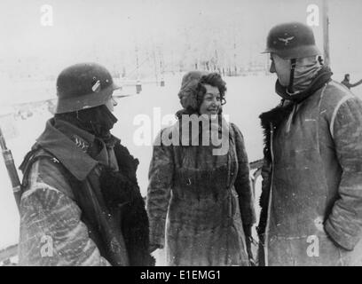 Soldaten der deutschen Wehrmacht stehen neben einer Schauspielerin einer Theatergruppe an der Ostfront, veröffentlicht am 06. Februar 1942. Propagandatext! Aus den Nachrichten der Nazis auf der Rückseite des Bildes: "Wintereinsatz einer Vorderbühne. Eine Künstlerin im Gespräch mit zwei Soldaten. Pelze schützen vor der großen Kälte des russischen Winters." (Qualitätsmängel aufgrund der historischen Bildkopie) Fotoarchiv für Zeitgeschichtee - KEIN KABELDIENST - Stockfoto