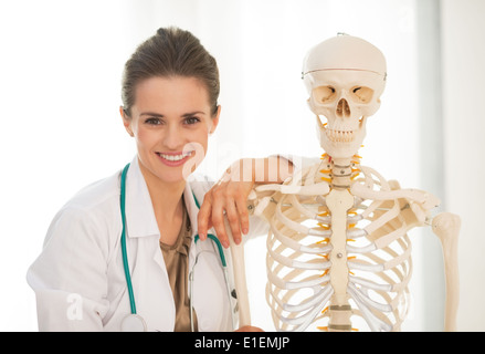 Porträt der lächelnde Frau Doktor der Medizin in der Nähe von menschlichen Skelett anatomisches Modell Stockfoto