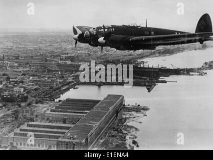 A German Luftwaffe Heinkel He 111flies über dem deutschen besetzten Hafen von Mykolaiv, Ukraine, 1941. Der Originaltext eines Nazi-Nachrichtenberichts auf der Rückseite des Bildes lautet: "Über dem Hafen von Mykolaiv zum Feind. Ein He 111 über dem Hafen der ukrainischen Schwarzmeerstadt Mykolaiv am Southern Bug. Vor ein paar Wochen wurde es den deutschen Truppen in einem kühnen Angriff genommen. Unsere Kampfflugzeuge fliegen über die Stadt und weiter, um Konvois auf dem Schwarzen Meer oder sowjetischen Verbindungen zu zerstören." Fotoarchiv für Zeitgeschichtee - KEIN KABELDIENST Stockfoto