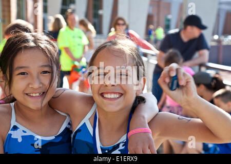 Arlington, Virginia, USA. 1. Juni 2014. Sofia Rosato (8, rechts) und Sophie Bolin (9, links) gerade ihren ersten Triathlon abgeschlossen. Der Arlington Triathlon Club organisiert die erste Jugend-Triathlon in Arlington, VA. Die Veranstaltung war Teil des Arlington Jugendfestivals Multisport Stockfoto