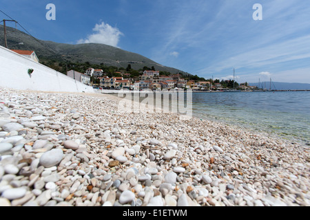 Dorf von Agia Efimia, Kefalonia. Agia Efimias Kieselstrand mit der Uferpromenade Taverna im Hintergrund. Stockfoto