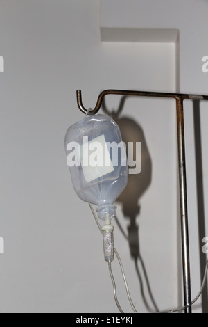 Eine leere Glukose-Flasche auf einem Ständer in einem Krankenzimmer, verwendet für die Lieferung von Glukose oder einer Kochsalzlösung mit Schlauch Stockfoto