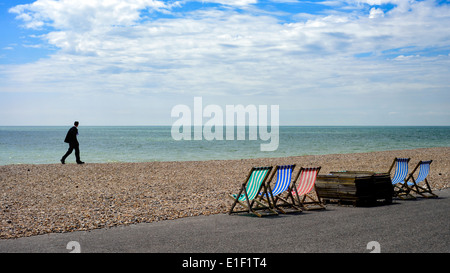 Ein Mann geht Worthing Strand trägt einen Anzug auf eigene Faust entlang. Bild von Julie Edwards Stockfoto
