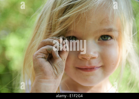 Kind blondes Girl Holding Wurm draußen im Garten, Porträt, Sommer Stockfoto