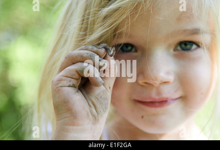 Kind blondes Girl Holding Wurm draußen im Garten, Porträt, Sommer Stockfoto