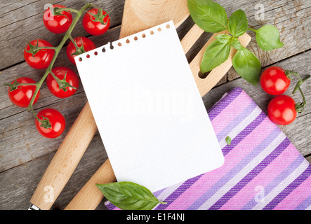 Leere Notizblatt Papier für Ihre Rezepte mit Tomaten und Basilikum auf Holztisch Stockfoto