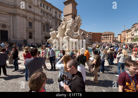 Menschenmenge in der Piazza Navona am vier Flüsse-Brunnen an einem sonnigen Frühlingstag, Rom Italien Europa Stockfoto