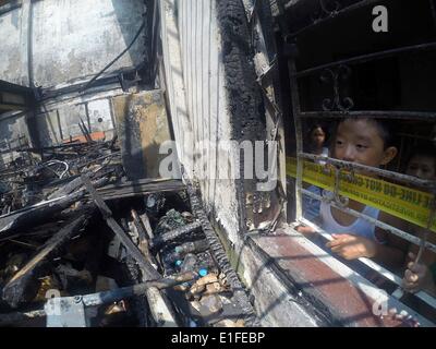 Manila, Philippinen. 3. Juni 2014. Kinder sehen in das verbrannte zweistöckige Gebäude in Manila, Philippinen, 3. Juni 2014. Fünf Menschen starben in dem Brandereignis wie Brandstiftung Ermittler die Ursache des Feuers untersuchen. Bildnachweis: Rouelle Umali/Xinhua/Alamy Live-Nachrichten Stockfoto