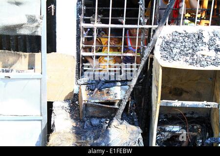 Manila, Philippinen. 3. Juni 2014. Kinder sehen in das verbrannte zweistöckige Gebäude in Manila, Philippinen, 3. Juni 2014. Fünf Menschen starben in dem Brandereignis wie Brandstiftung Ermittler die Ursache des Feuers untersuchen. Bildnachweis: Rouelle Umali/Xinhua/Alamy Live-Nachrichten Stockfoto