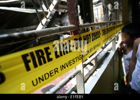 Manila, Philippinen. 3. Juni 2014. Kinder sehen in das verbrannte zweistöckige Gebäude in Manila, Philippinen, 3. Juni 2014. Fünf Menschen starben in dem Brandereignis wie Brandstiftung Ermittler die Ursache des Feuers untersuchen. Bildnachweis: Rouelle Umali/Xinhua/Alamy Live-Nachrichten Stockfoto