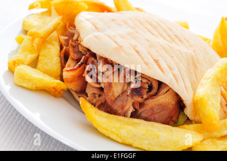 Döner in einem Teller mit Pommes Frites auf einem gedeckten Tisch Stockfoto