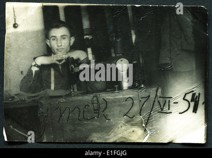 UdSSR - ca. 1954: Eine antike Foto zeigt einen jungen Mann an der Nähmaschine Stockfoto