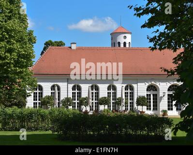 Blick auf die Orangerie am Schloss Neuhardenberg und der Turm der Schinkel-Kirche in Neuherdenberg, 30. Mai 2014. 1997 wurde das Herrenhaus durch die Einsparung Banken Verband Deutscher Sparkassen-Und Giroverband erworben und restauriert für 60 Millionen Euro. Preußischen Königs Friedrich Wilhelm III. hatte die Eigenschaft seine staatliche Kanzler Fürst Karl August von Hardenberg für seine Beiträge zur Reform des preußischen Staates im Jahre 1814 gegeben. Foto: Patrick Pleul/dpa Stockfoto