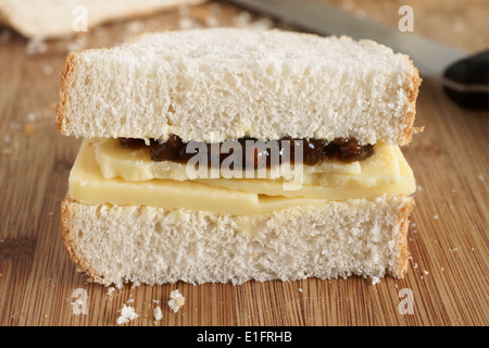 Im rustikalen Stil Hand schneiden Cheddar Käse und eingelegten Gurken Sandwich mit knusprigem hausgemachte Brot Stockfoto