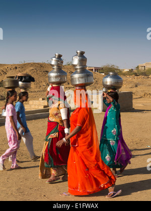 Indien, Rajasthan, Jaisalmer, Thar-Wüste, Khuri, Frauen in bunten Saris Wassertragen vom Dorf gut gekleidet Stockfoto