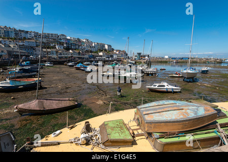 Hafen von BRIXHAM Devon bei Ebbe mit Booten und Yachten vor Anker. Boot mit Beiboot auf Deck im Vordergrund. Häuser im Hintergrund Stockfoto