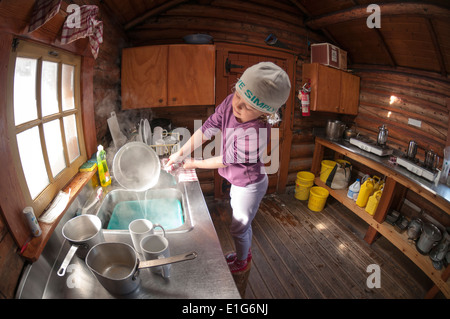 Ein junges Mädchen Geschirrspülen im Elizabeth Parker Hütte, Lake O'Hara, Yoho-Nationalpark, Field, Britisch-Kolumbien, Kanada. Stockfoto