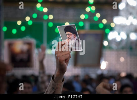 Teheran, Iran. 3. Juni 2014. Ein iranischer Mann hält Sie ein Porträt des Irans oberster Führer Ayatollah ALI KHAMENEI während der Teilnahme an einer Zeremonie anlässlich der Todestag des Irans spät Führer Ayatollah RUHOLLAH KHOMEINI in Khomeinis Schrein in Behesht Zahra-Friedhof in südlichen Teheran. (Credit: Credit: Morteza Nikoubazl/ZUMAPRESS.com/Alamy Live-Nachrichten) Stockfoto