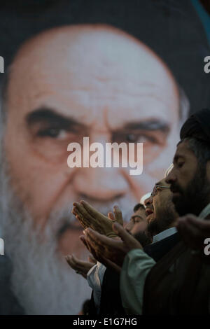 Teheran, Iran. 3. Juni 2014. Kleriker beten, wie sie vor ein riesiges Porträt des Irans spät Führer Ayatollah RUHOLLAH KHOMEINI, während einer Zeremonie anlässlich der Todestag von Ayatollah KHOMEINI in Khomeinis Schrein in Behesht Zahra-Friedhof in südlichen Teheran stehen. (Credit: Credit: Morteza Nikoubazl/ZUMAPRESS.com/Alamy Live-Nachrichten) Stockfoto
