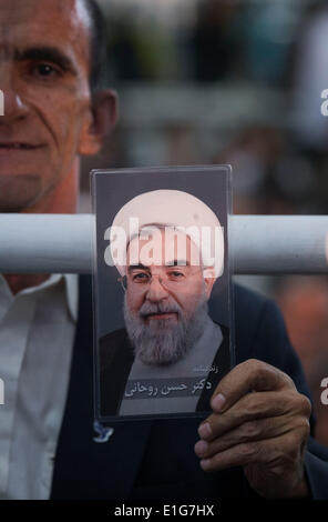 Teheran, Iran. 3. Juni 2014. Ein iranischer Mann hält ein Porträt des Irans Präsident HASSAN ROUHANI während der Teilnahme an einer Zeremonie anlässlich der Todestag des Irans spät Führer Ayatollah RUHOLLAH KHOMEINI in Khomeinis Schrein in Behesht Zahra-Friedhof in südlichen Teheran. (Credit: Credit: Morteza Nikoubazl/ZUMAPRESS.com/Alamy Live-Nachrichten) Stockfoto
